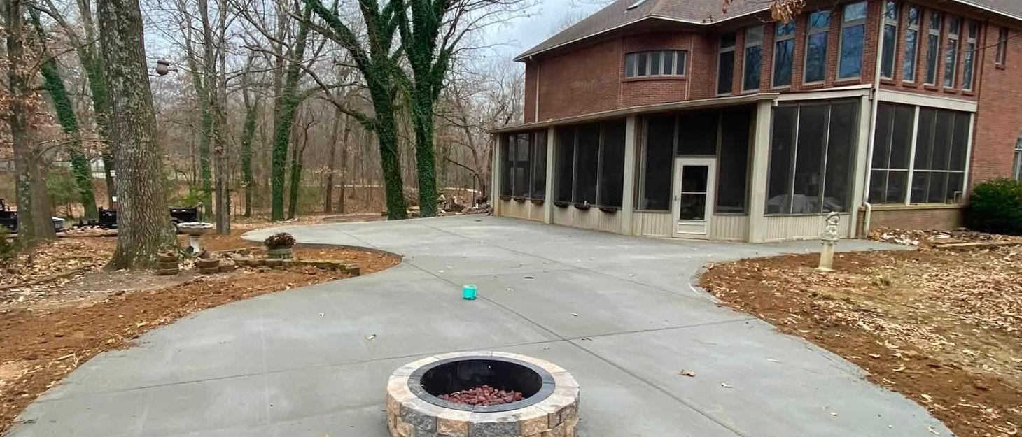 Backyard concrete patio with built-in fire pit and screened porch