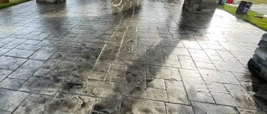 Stamped concrete patio with stone-clad pillars and outdoor fireplace