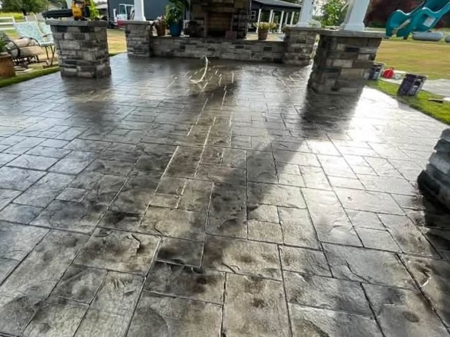 Stamped concrete patio with stone-clad pillars and outdoor fireplace, M.S. Outdoor Creations